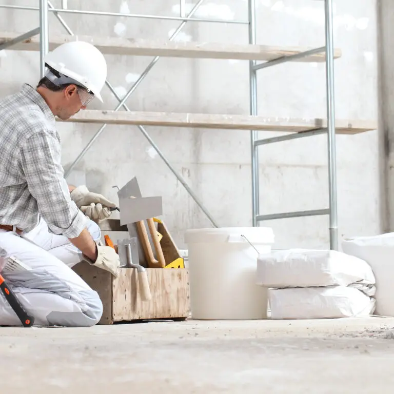plasterer man construction worker work with tool box wear gloves, hard hat and protection glasses at interior building site with scaffolding. bucket, sacks and jackhammer